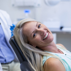 Woman smiling while sitting in dentist treatment chair