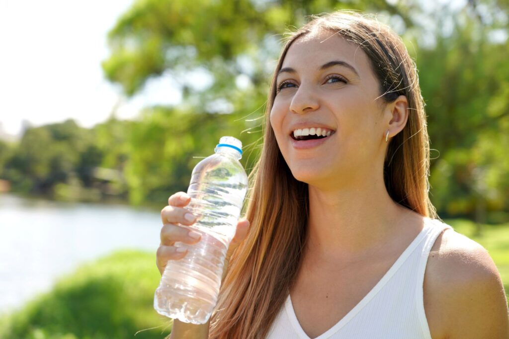 A woman drinking bottled water.